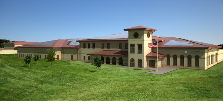 Architectural rendering of the West Palm Beach Reserve Center, a two-story civic building with solar panels on the roof and an American flag on the lawn.