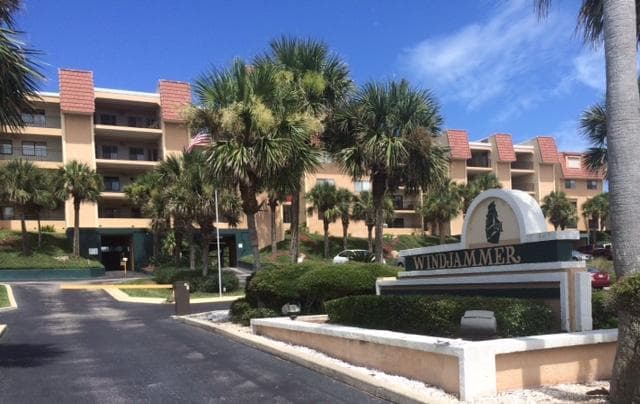 Entrance to Windjammer Condominiums in St. Augustine, Florida, with a monument sign, palm trees, and multi-story residential buildings in the background.